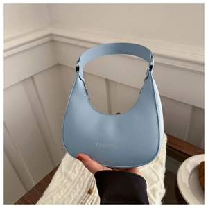 Detail of light blue crescent hobo bag with silver fashion lettering and smooth leather finish