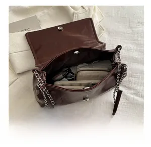 Detailed interior of a brown leather bag with silver chain strap and storage capacity