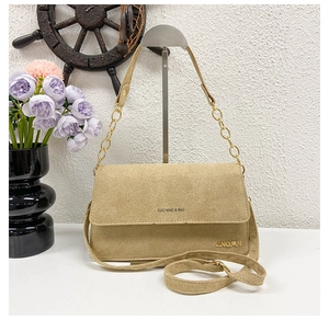 Detailansicht der khakifarbenen Wildledertasche mit Kettenriemen und Schriftzug