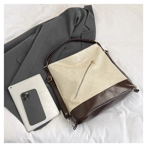 Detalle del bolso tote vintage de gran capacidad con correas dobles en fondo neutro