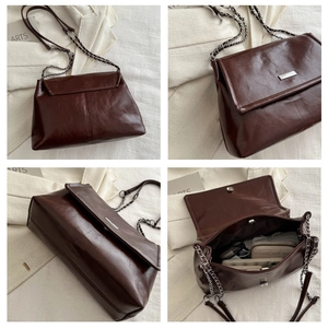 Detail of dark brown leather crossbody bag featuring silver metal buckle and chain strap