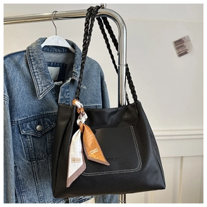 Detailansicht der schwarzen Tote Bag mit Kontrastnähten und dekorativem Seidenschal
