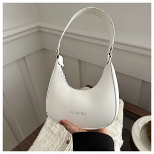 Detail of white half-moon hobo bag featuring silver FASHION lettering and metal hardware