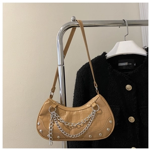 Detail of tan crocodile embossed leather shoulder bag with silver chain and studs