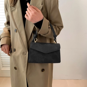 Chic black matte square handbag with braided handle and gold metal ring details