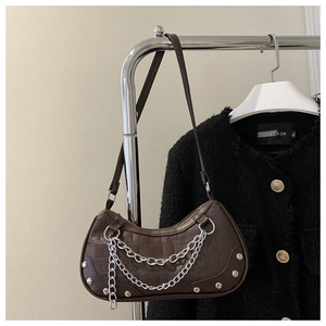 Close-up of dark brown crocodile pattern crescent bag with silver chains and rivets