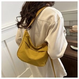 Détail d'un sac fourre-tout en nylon jaune moutarde porté pour un look décontracté