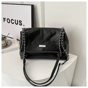 Close-up of black pleated PU leather handbag with metallic chain strap and silver nameplate