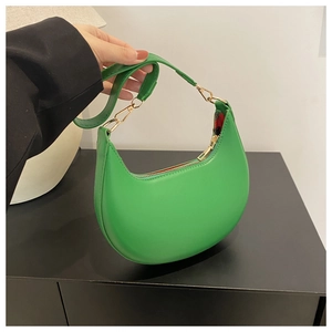 Detail of green hobo bag featuring smooth PU leather, gold zipper and shoulder strap