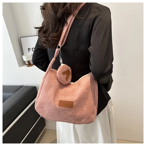 Pink corduroy crossbody tote bag with a small coin purse shown on the shoulder