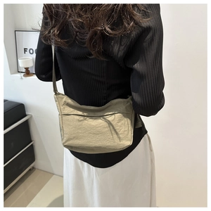 Grand sac fourre-tout en nylon vert olive porté en bandoulière pour montrer la taille