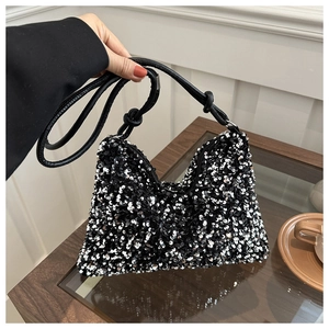 Detail of sequined shoulder bag showing the unique knot design on the black strap