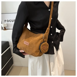 Brown corduroy tote bag detail with mini pouch and leather fashion label on model