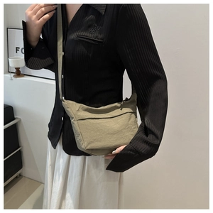 Gros plan du sac demi-lune en nylon vert olive avec une bandoulière réglable pratique