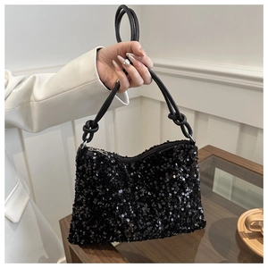 Detailed view of black sequined handbag featuring a luxury knotted leather strap design