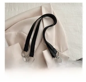 Detail of grey plaid wool tote bag with black leather handle and silver metal ring