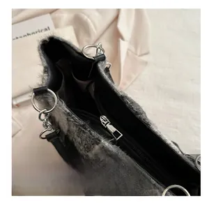 Detailed macro view of smooth metal zipper and silver ring on fuzzy plaid wool tote bag
