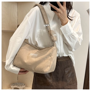 Dettaglio della borsa a tracolla in velluto beige con borsellino e logo del marchio