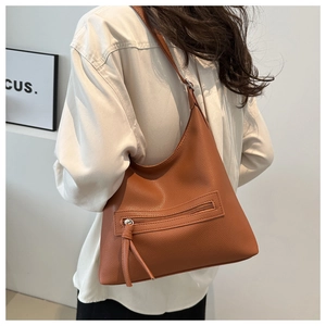 Detail of brown litchi pattern leather tote with tassel zipper and hobo shoulder strap
