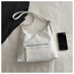 Close-up of white pebble leather hobo bag with front zipper and adjustable wide strap