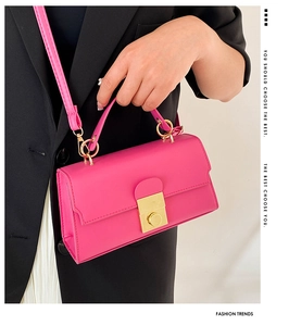 Detailed view of magenta crossbody bag with gold metallic lock and smooth PU leather finish