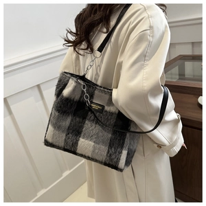Detailed view of checkered wool tote bag with leather strap and metal chain details