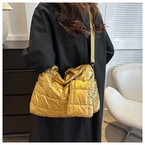 Quilted metallic gold puffy tote bag with matching square coin purse shown on model