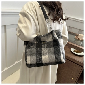 Detail of wool tote bag with black and white plaid pattern and silver chain strap