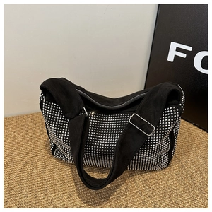 Detail of black suede hobo bag with silver studs and adjustable wide shoulder strap