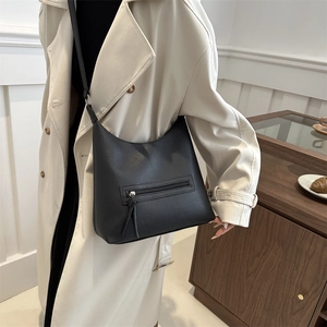 Large capacity black pebble leather tote bag with front zipper and tassel strap detail