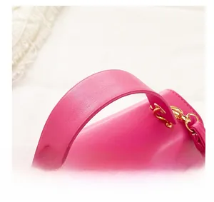 Detail show of wide comfortable handle and gold metal hardware on rose pink handbag