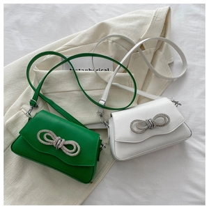 Détail des sacs à bandoulière verts et blancs avec boucles en nœud de strass