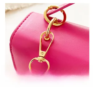 Detail of detachable golden metal hook and hardware on pink leather shoulder bag