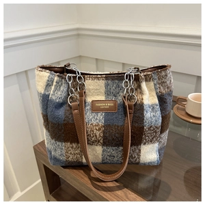 Close-up of retro plaid wool tote bag with leather tag and metal chain strap detail