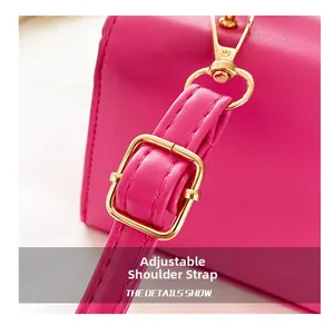 Detail view of the adjustable magenta leather shoulder strap with a golden metal buckle