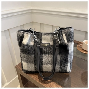 Detail of wool-like plaid tote bag showing soft checkered texture and metal chain strap