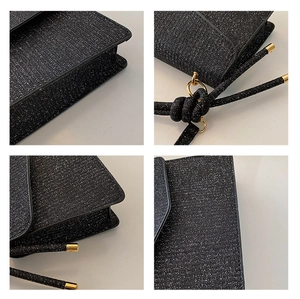 Close-up of glitter fabric texture and fine stitching on the black square crossbody bag