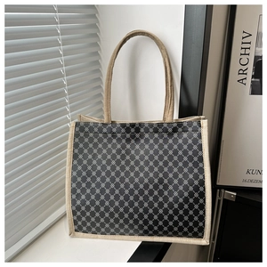 Detail of navy geometric print tote bag with beige woven canvas straps and piping