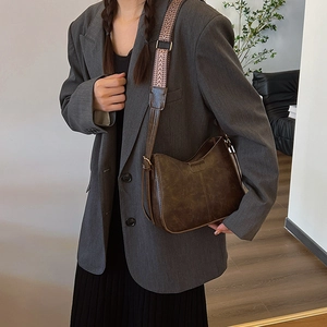 Vintage dark brown crossbody bag with a wide geometric patterned shoulder strap