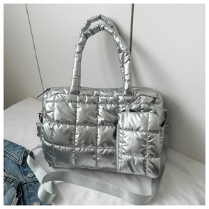 Detail of silver quilted tote bag with metallic finish and matching small zipper pouch