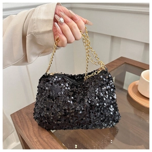 Detail of black sequined evening clutch bag with golden chain and zip closure