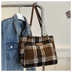 Detail of checkered plush tote bag featuring faux fur texture and leather strap accents