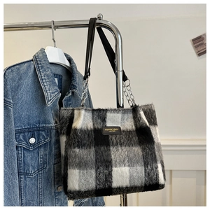 Detail of wool plaid tote bag featuring plush texture and silver metal chain strap