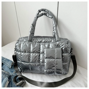 Detailed close-up of silver quilted puffer tote bag with matching mini pouch and strap