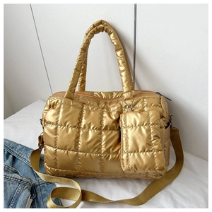 Close-up of golden quilted puffer bag with matching mini pouch and nylon strap details