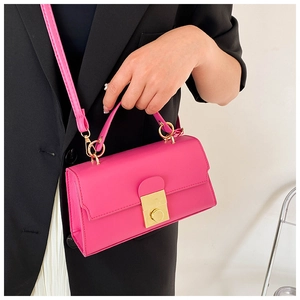 Detail of hot pink crossbody bag with gold metal lock and leather top handle