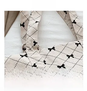 Detail shot of corduroy fabric with diamond quilting and bow pattern on shoulder bag