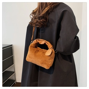Detailed view of brown plush tote bag with ruched leather handle and faux fur texture