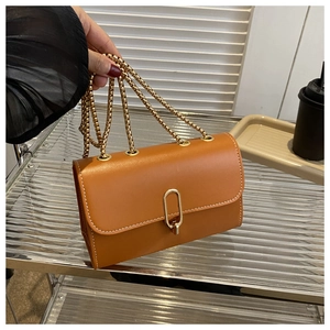 Detail of caramel leather crossbody bag with white contrast stitching and gold clasp