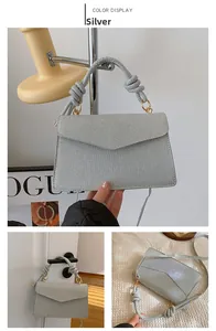 Detail view of silver shiny handbag featuring woven texture and unique knotted handle